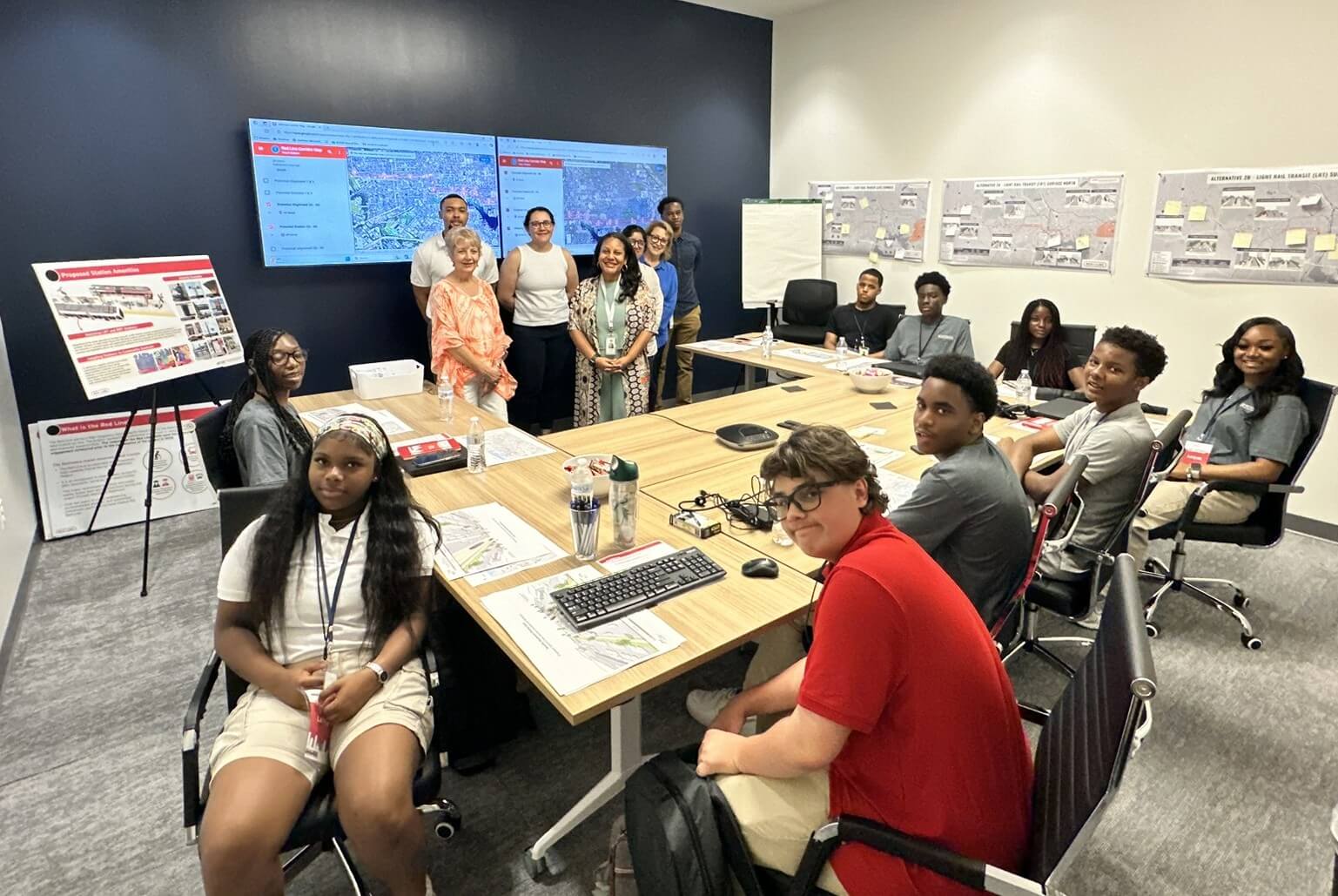 2025 Red Line Interns seated around a table with maps on the walls